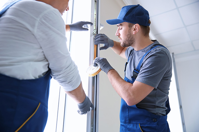 professionals in blue jumpers working on garage doors