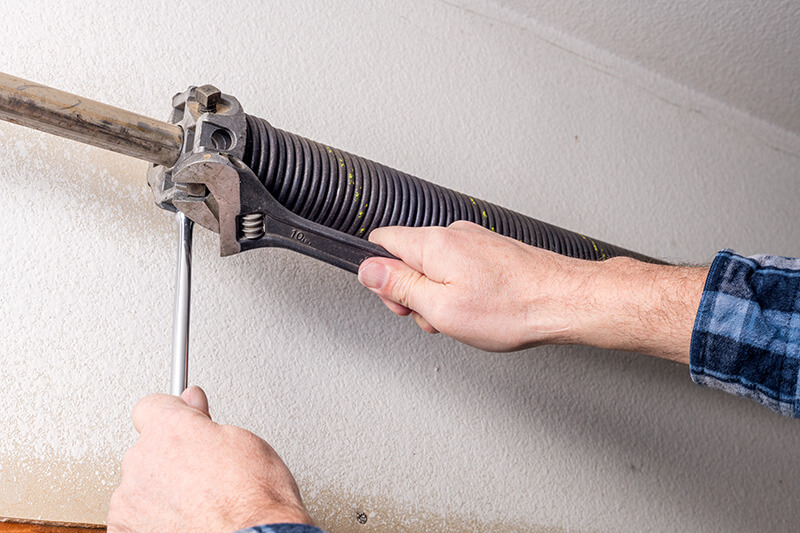 professional performing garage door spring repair duties